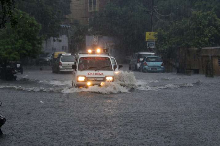 An ambulance makes way through a flooded road after... An ambulance makes way through a flooded road after...- India TV