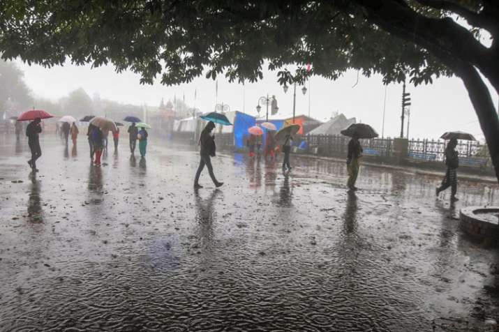 People protect themselves with umbrellas during heavy... People protect themselves with umbrellas during heavy...- India TV