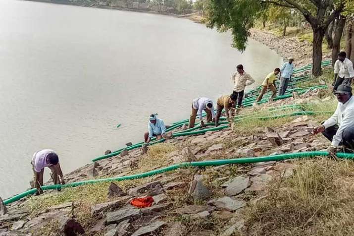 Administration employees drain water from the 36-acre... Administration employees drain water from the 36-acre...- India TV