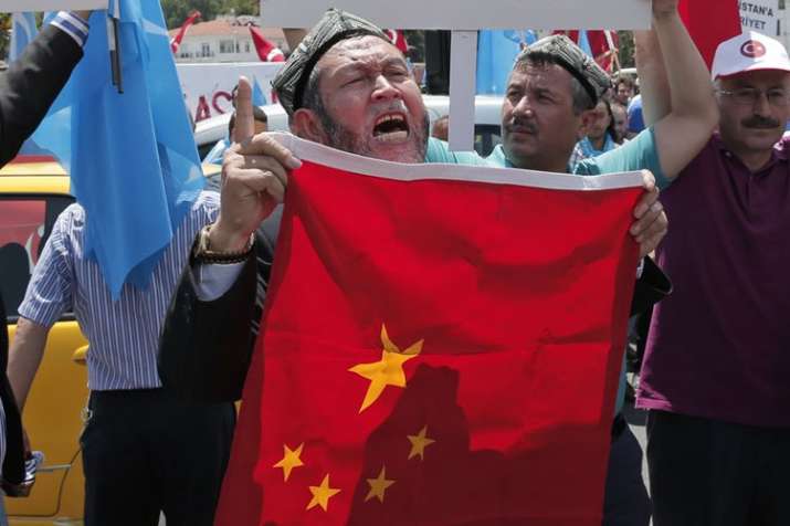 Uighurs living in Turkey and Turkish supporters, chant slogans as they hold a Chinese flag | AP File Uighurs living in Turkey and Turkish supporters, chant slogans as they hold a Chinese flag | AP File- India TV