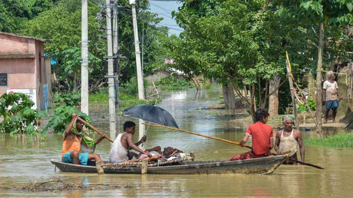 Flood-affected villagers use a boat to take a patient to... Flood-affected villagers use a boat to take a patient to...- India TV