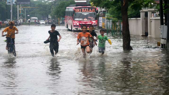 Children play at a waterogged road following heavy monsoon rain in Varanasi Children play at a waterogged road following heavy monsoon rain in Varanasi- India TV