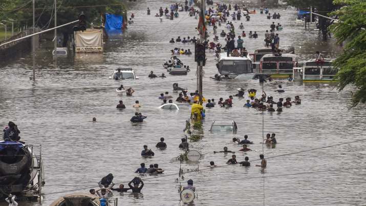 People wade through a flooded railway tracks during heavy rain, in Mumbai. People wade through a flooded railway tracks during heavy rain, in Mumbai.- India TV
